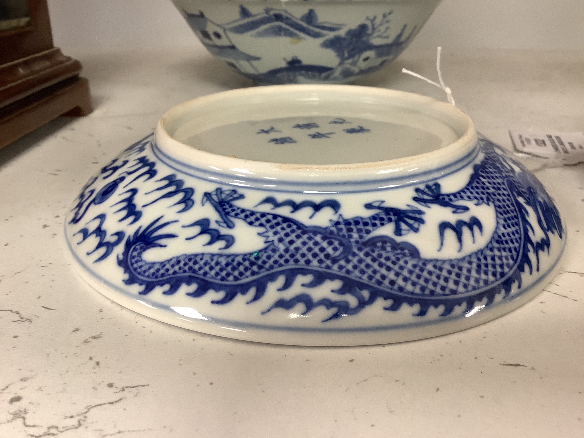 A Chinese blue and white landscape bowl, a/f and a Chinese blue and white ‘dragon’ dish, 18 and 16.5 cm